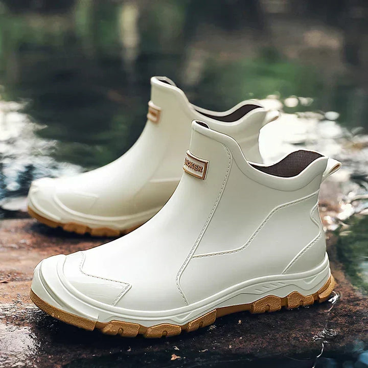 Women's waterproof ankle rain boots in slip-on style with textured tread sole and reinforced toe cap