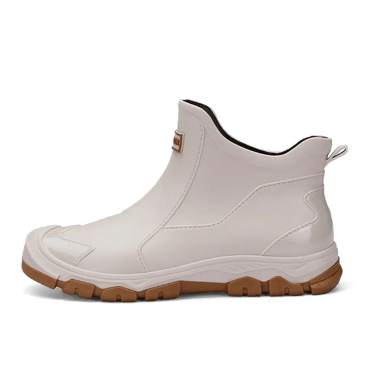 Women's waterproof ankle rain boots in slip-on style with textured tread sole and reinforced toe cap