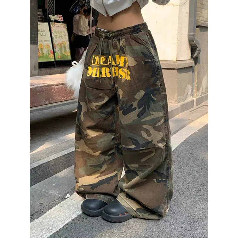 Baggy camouflage trousers with yellow front text and drawstring waist