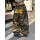 Baggy camouflage trousers with yellow front text and drawstring waist