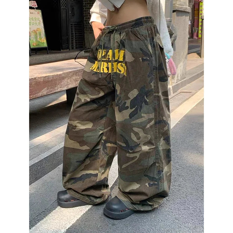 Baggy camouflage trousers with yellow front text and drawstring waist