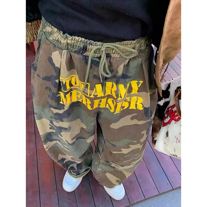 Baggy camouflage trousers with yellow front text and drawstring waist