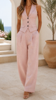 Woman wearing sleeveless tailored waistcoat with wide-leg trousers in a two-piece set