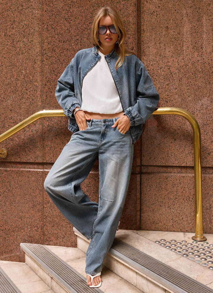 Women's mid-wash blue denim bomber jacket with high collar and zip front