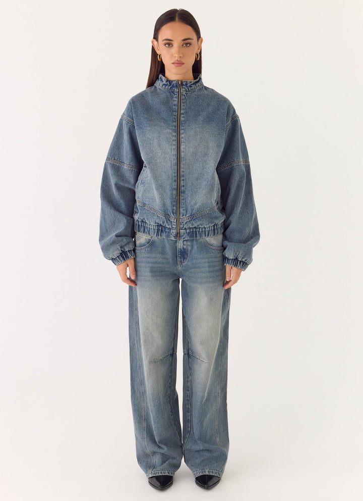 Women's mid-wash blue denim bomber jacket with high collar and zip front