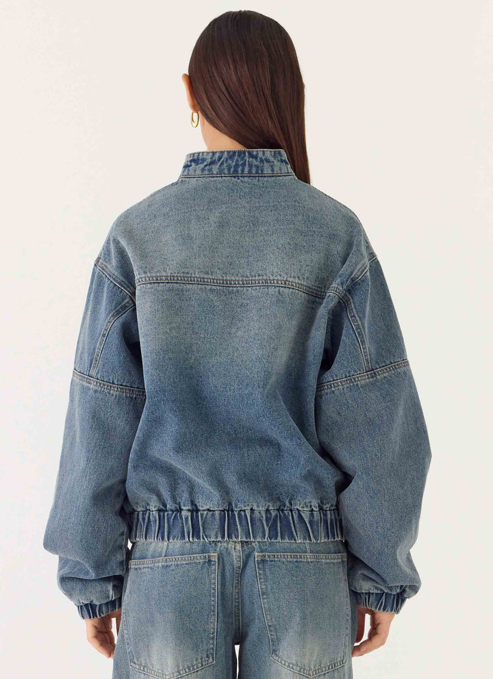 Women's mid-wash blue denim bomber jacket with high collar and zip front
