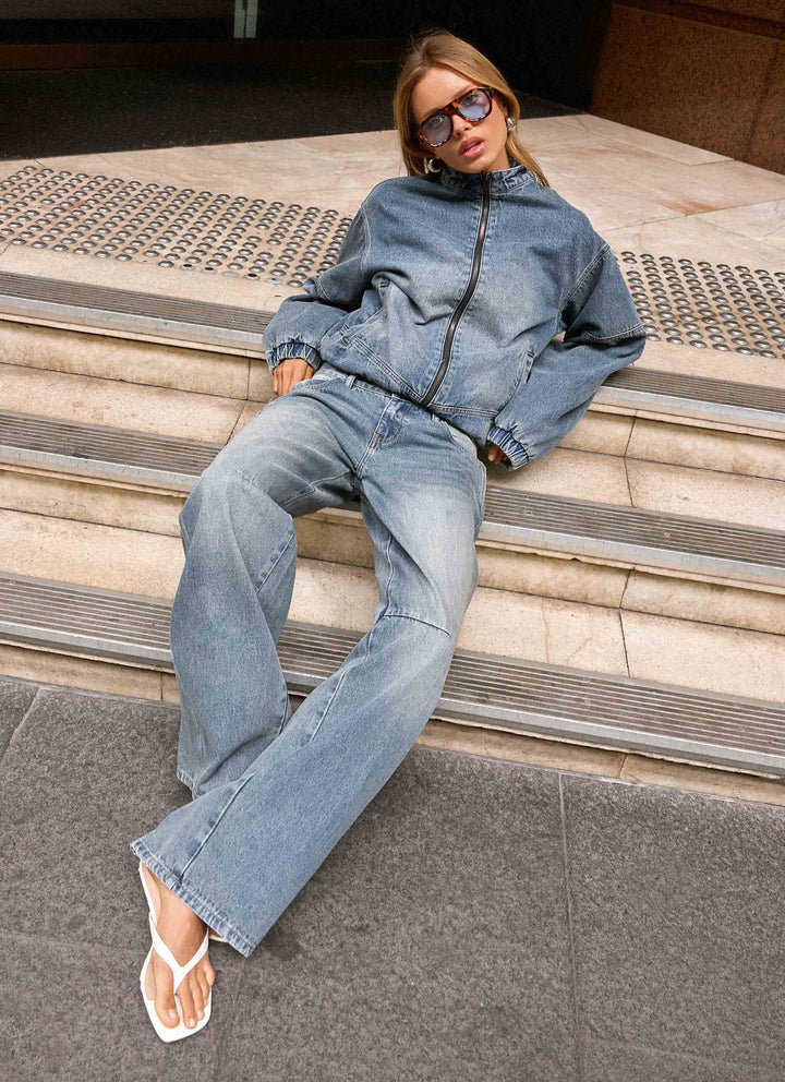 Women's mid-wash blue denim bomber jacket with high collar and zip front