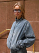 Women's mid-wash blue denim bomber jacket with high collar and zip front