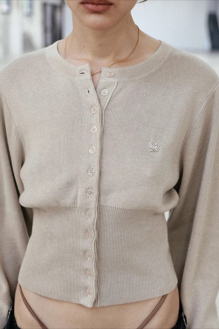 Women's cropped button cardigan with long sleeves and embroidered chest motif
