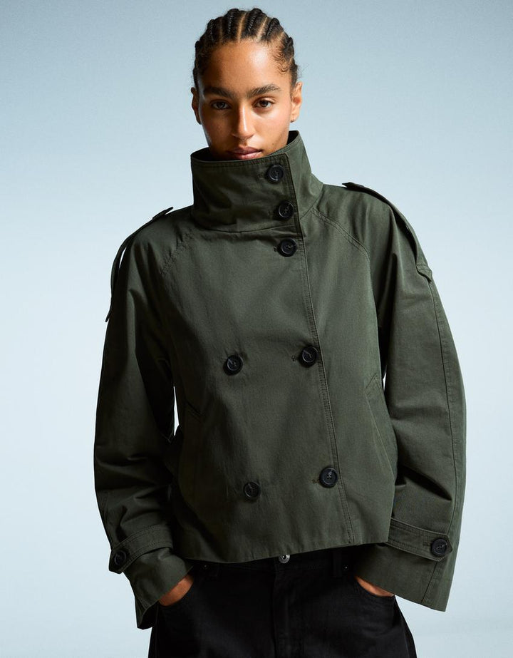 Women's short trench jacket with high collar, buttons, belt and shoulder tabs