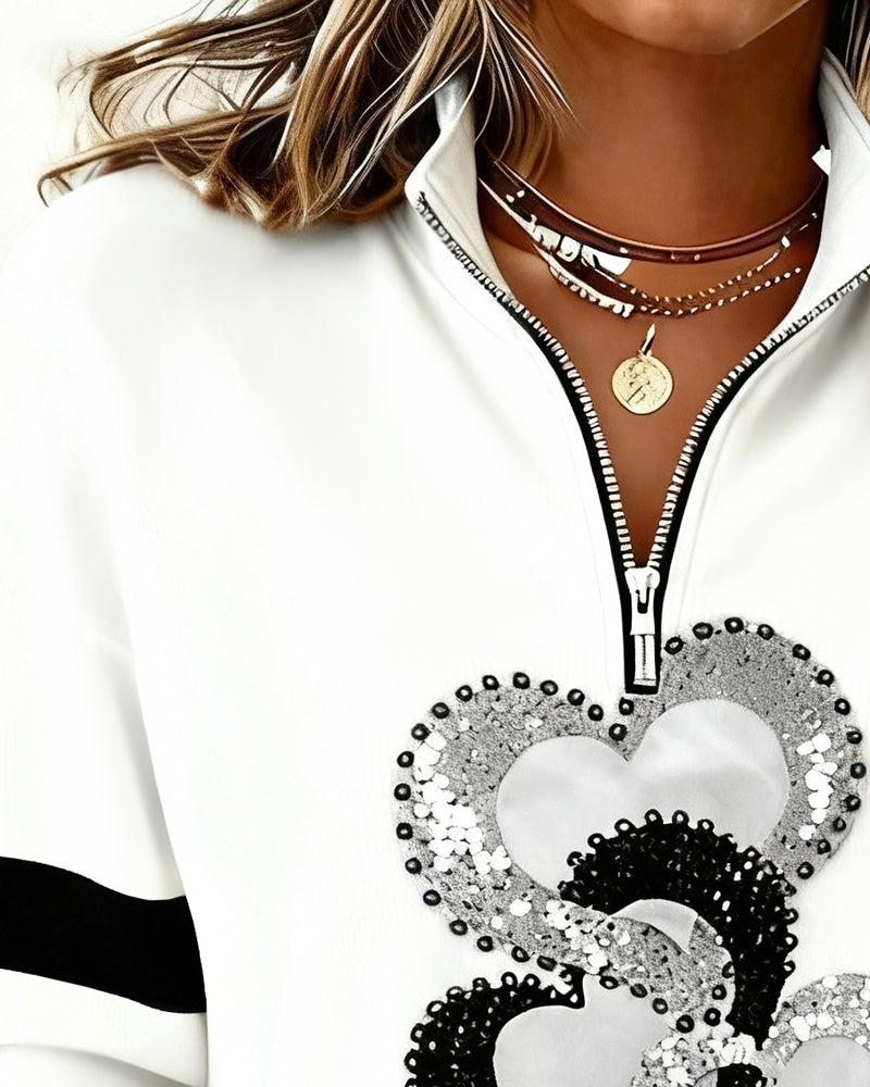 Women's white half zip sweatshirt with heart sequin design and black sleeve stripes