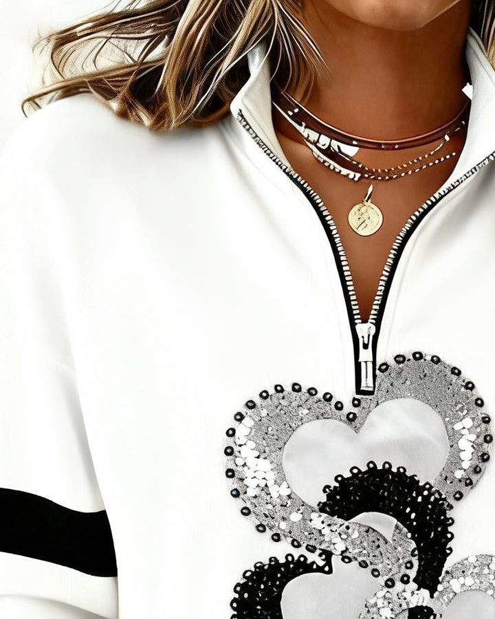 Women's white half zip sweatshirt with heart sequin design and black sleeve stripes