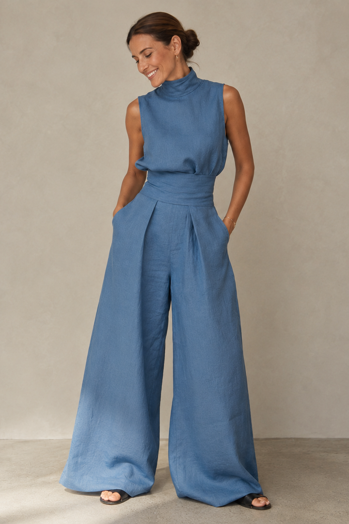 Women's sleeveless turtleneck jumpsuit in olive green and cream, wide-leg tailored trousers, high waist.