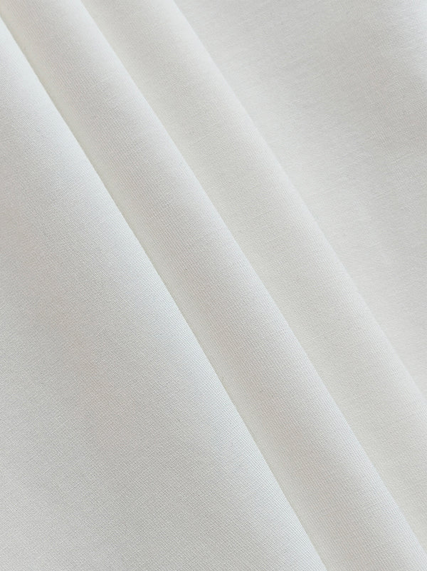 White women's high-neck long-sleeve top with asymmetric pleated shoulder detail