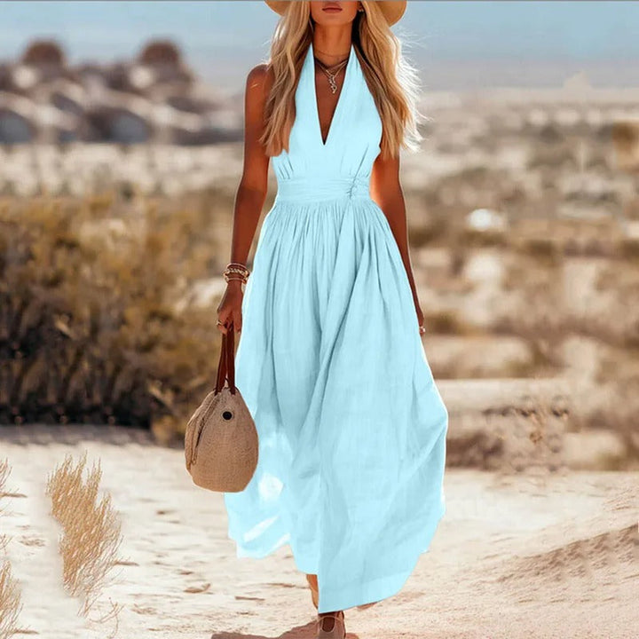 Women's halter maxi dress in brown and white with V-neck, sleeveless cut, and pleated skirt