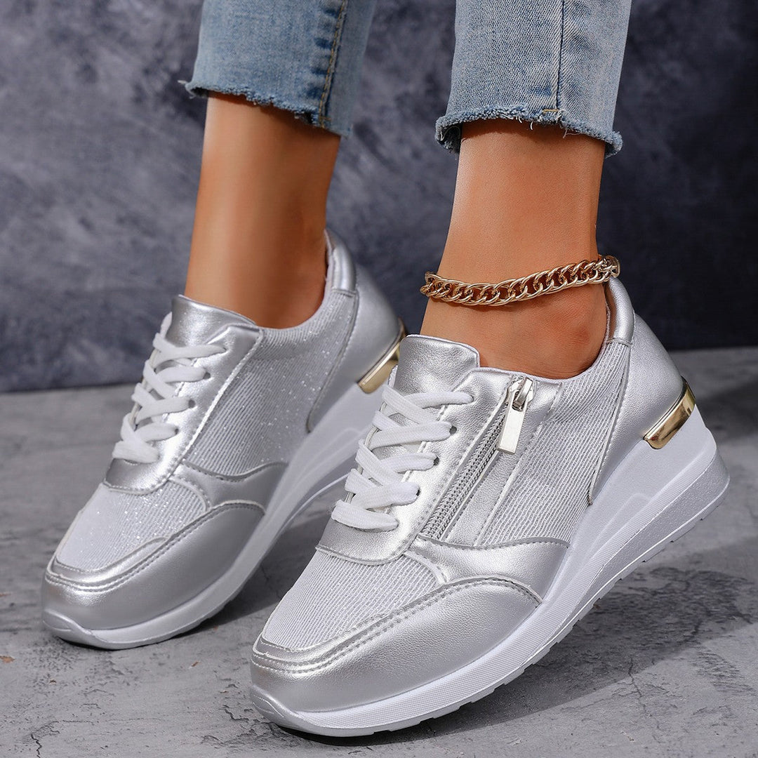 Women's silver metallic platform sneaker with lace-up front, side zip, and chunky white sole