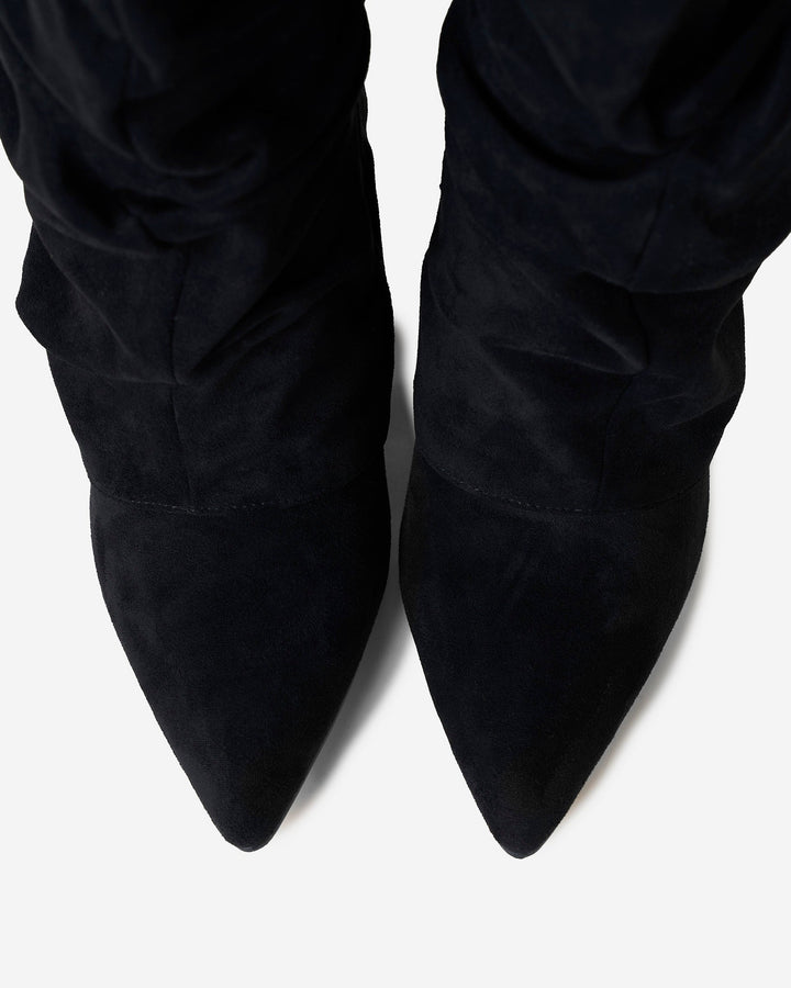 Women's black slouchy knee-high boots with pointed toes and buckle straps