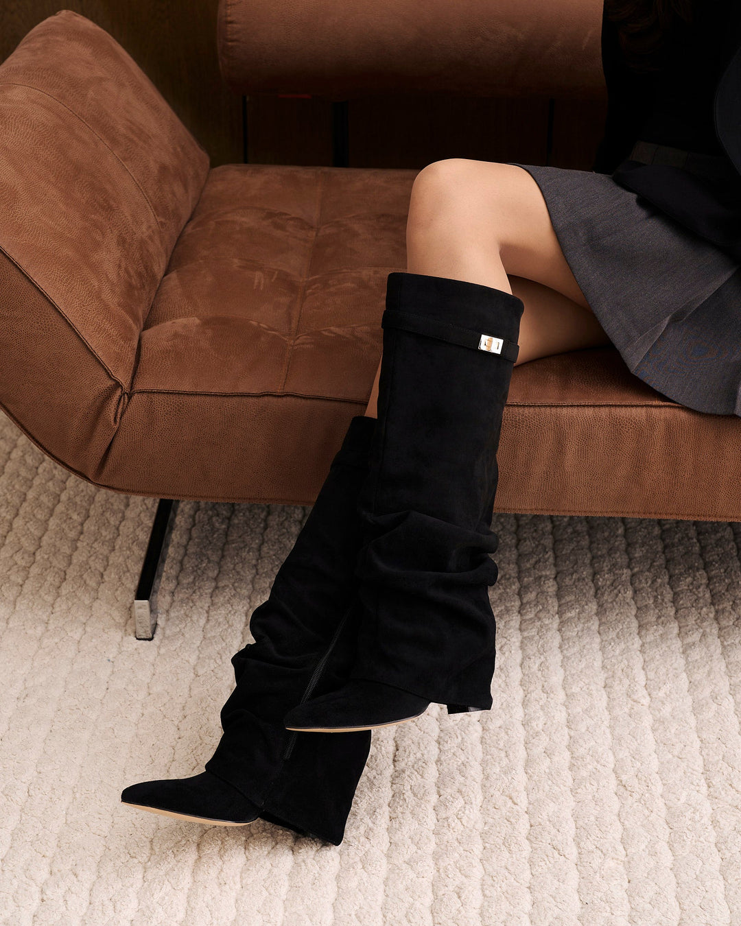 Women's black slouchy knee-high boots with pointed toes and buckle straps
