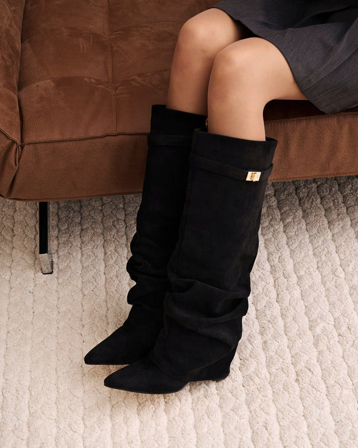 Women's black slouchy knee-high boots with pointed toes and buckle straps