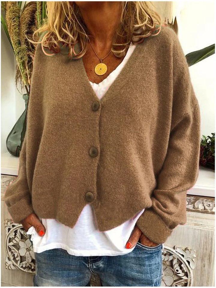 Women's long-sleeve V-neck button front cardigan layered over a white top and jeans