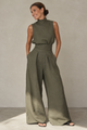 Women's sleeveless turtleneck jumpsuit in olive green and cream, wide-leg tailored trousers, high waist.