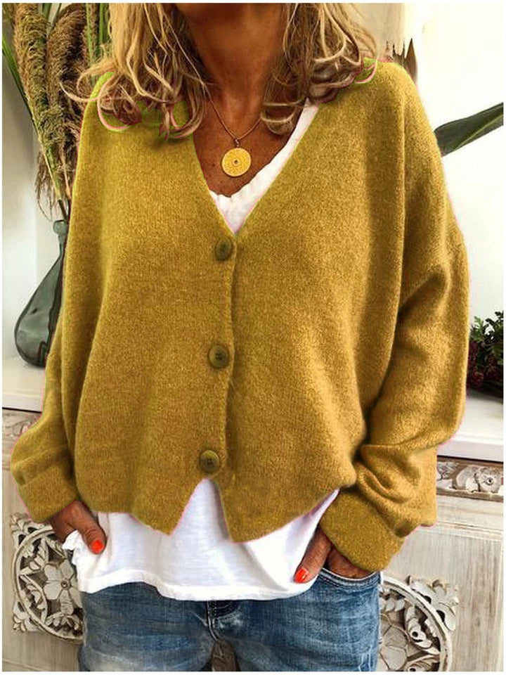 Women's long-sleeve V-neck button front cardigan layered over a white top and jeans