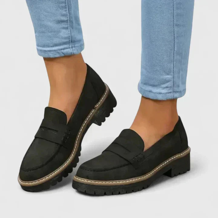 Women's black platform loafer with lug sole and padded band, shown on foot with jeans; also shown in pink with contrast sole and stitching