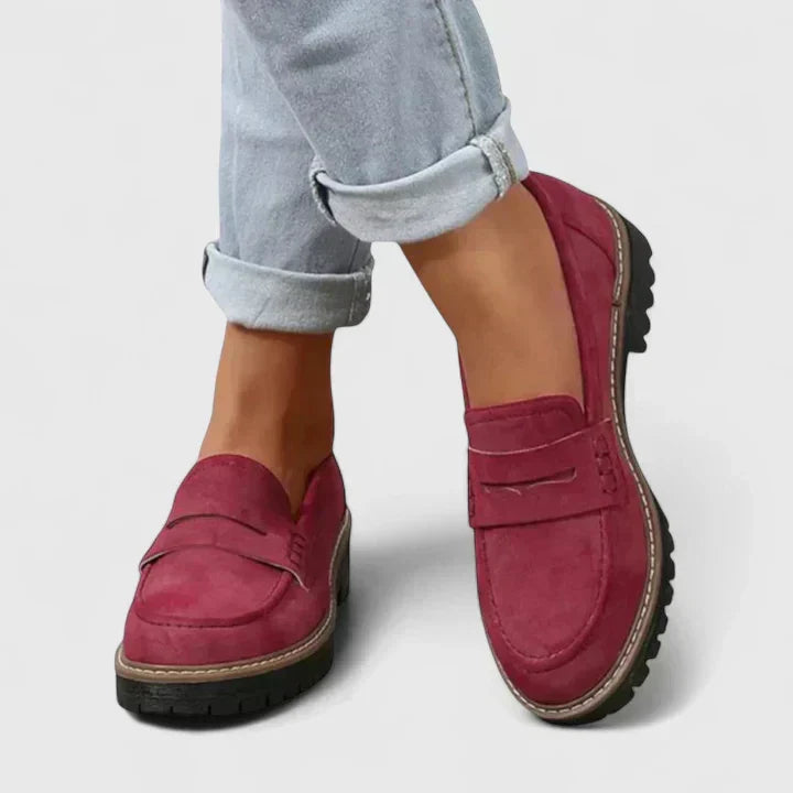 Women's black platform loafer with lug sole and padded band, shown on foot with jeans; also shown in pink with contrast sole and stitching