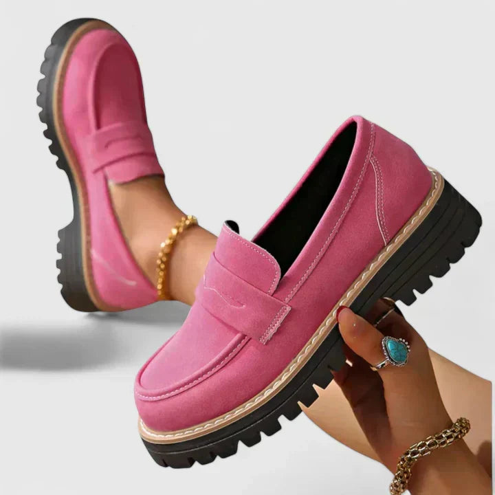 Women's black platform loafer with lug sole and padded band, shown on foot with jeans; also shown in pink with contrast sole and stitching
