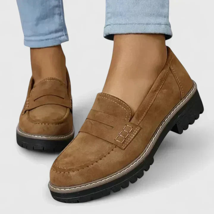 Women's black platform loafer with lug sole and padded band, shown on foot with jeans; also shown in pink with contrast sole and stitching