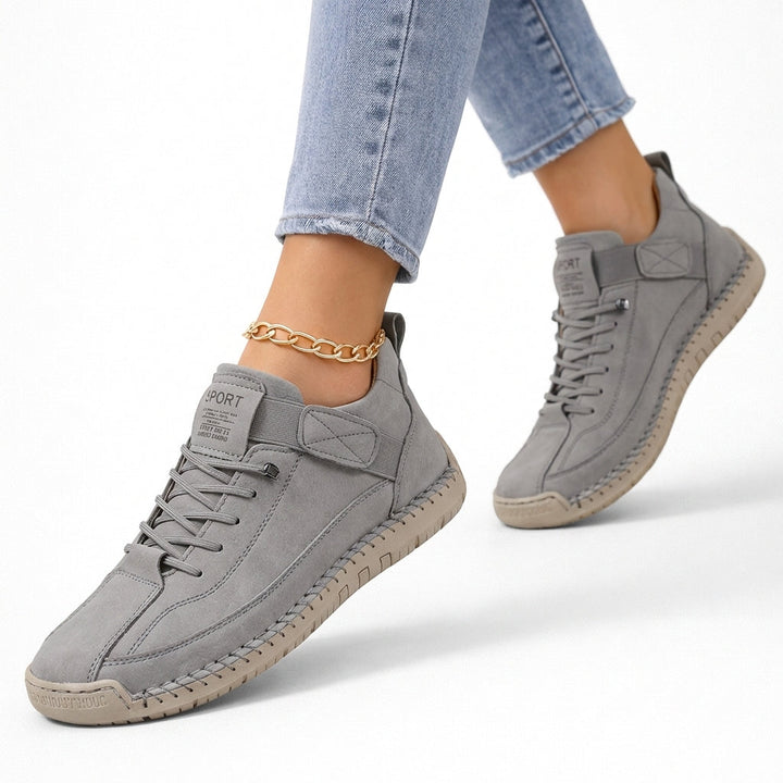 Women's low-top lace-up sneakers with stitched panels, strap detail and flat textured soles